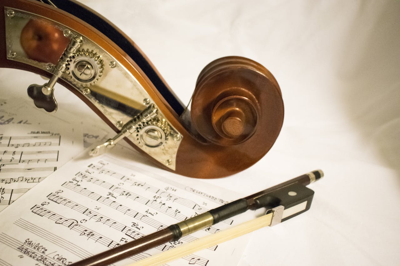 Capture of a bass scroll and bow on sheet music, highlighting musical details.